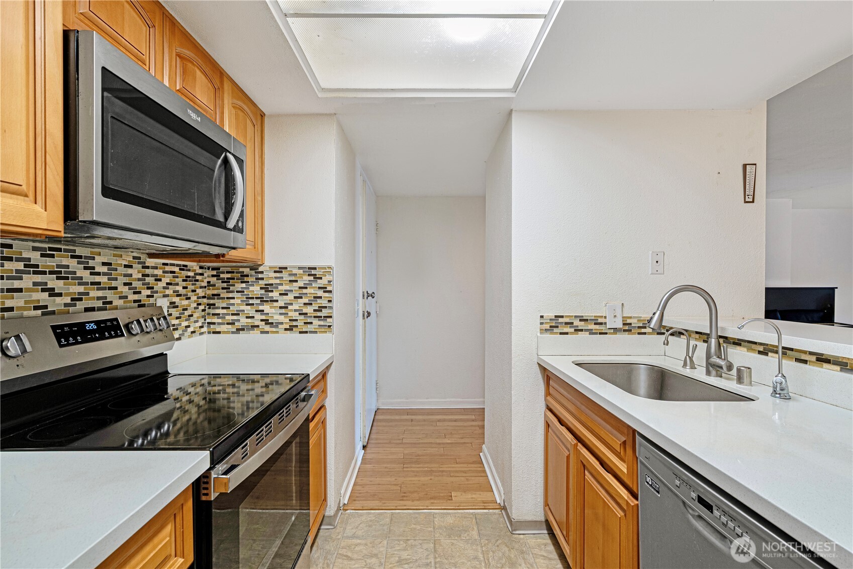 611 Southwest 5th Court, Unit A206 Renton, WA 98057 - Photo 3 of 21 a kitchen with stainless steel appliances granite countertop a sink stove and microwave