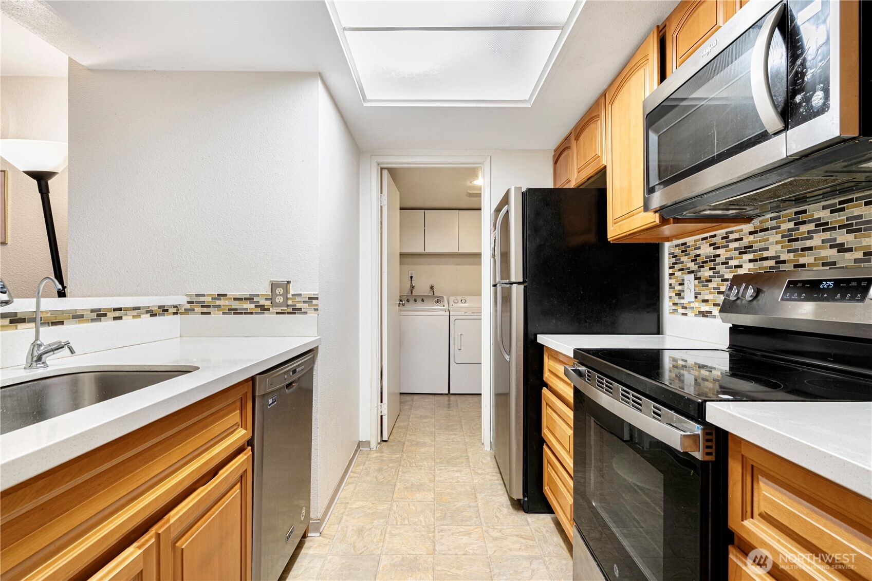 611 Southwest 5th Court, Unit A206 Renton, WA 98057 - Photo 4 of 21 a kitchen with stainless steel appliances granite countertop a sink and a refrigerator