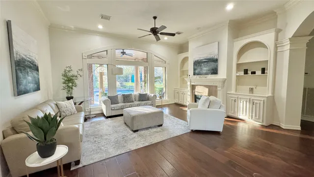 a living room with fireplace furniture and a large window
