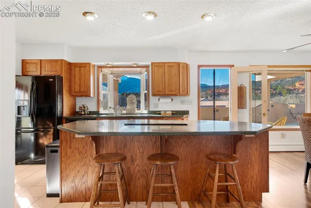a kitchen with stainless steel appliances granite countertop a sink and a refrigerator