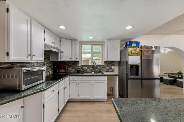 a kitchen with stainless steel appliances granite countertop a refrigerator sink and cabinets