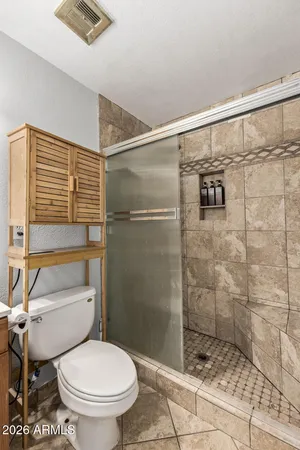 a bathroom with a toilet and a shower