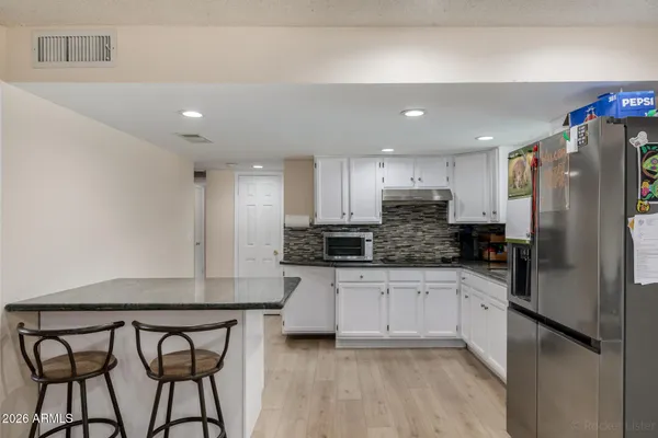 a kitchen with stainless steel appliances granite countertop a refrigerator a stove a sink and a microwave