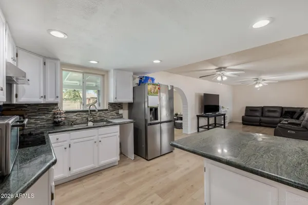a kitchen with a sink a counter top space stainless steel appliances and cabinets