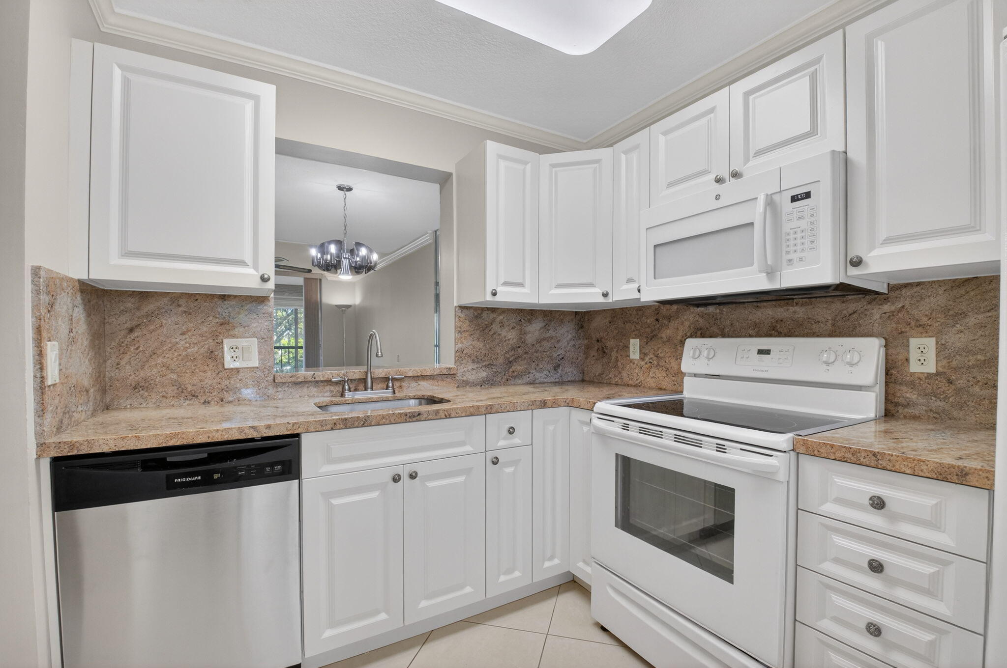 6935 Huntington Lane, Unit 207 Delray Beach, FL 33446 - Photo 22 of 88 a kitchen with granite countertop white cabinets and white appliances