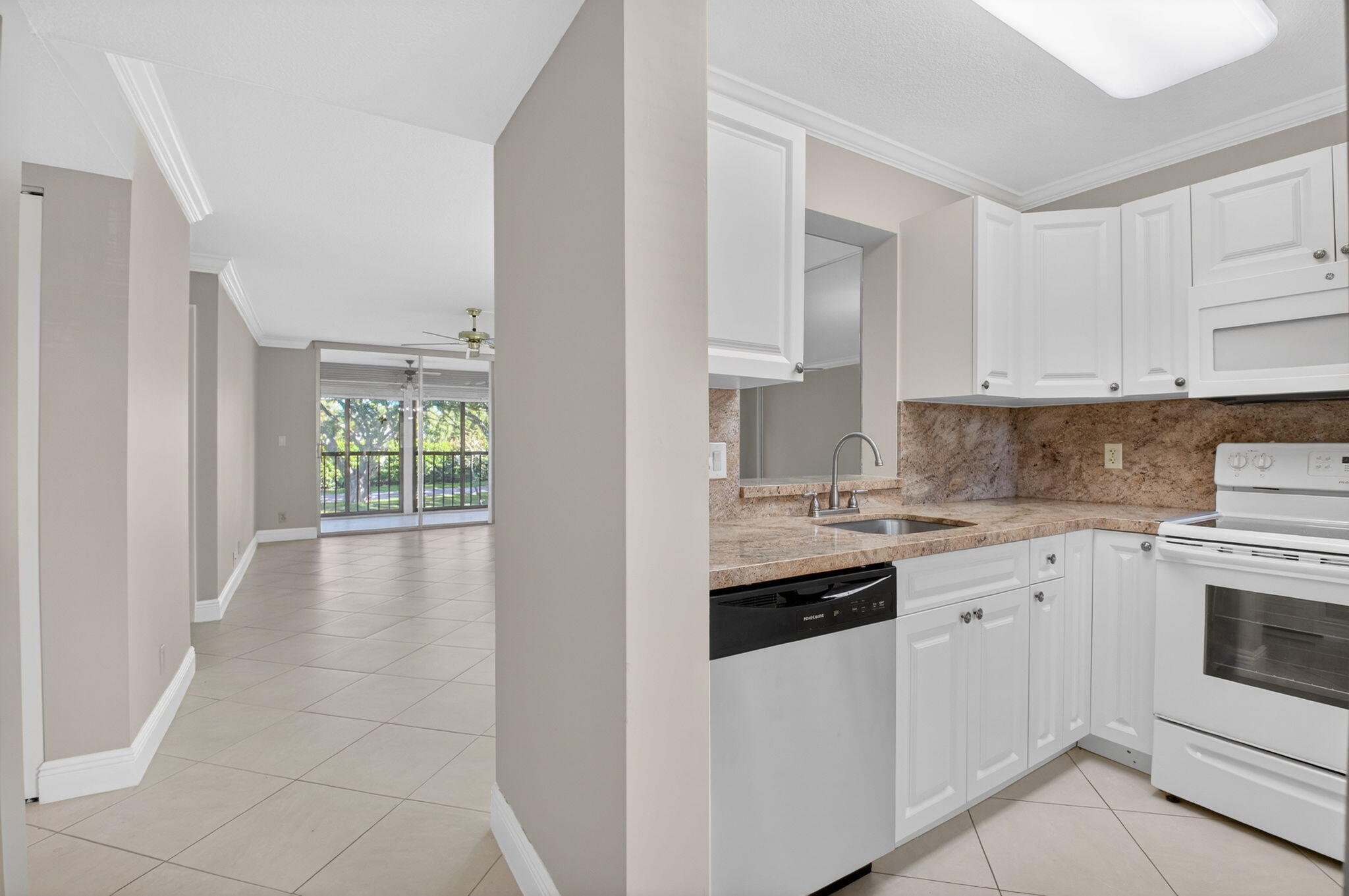 6935 Huntington Lane, Unit 207 Delray Beach, FL 33446 - Photo 7 of 88 a kitchen with granite countertop white cabinets and white appliances