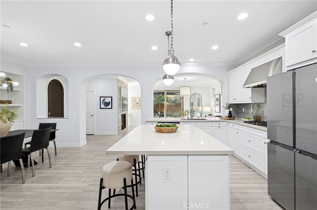 28274 Camino Del Rio San Juan Capistrano, CA 92675 - Photo 9 of 30 a kitchen with stainless steel appliances a refrigerator a stove a sink a dining table and chairs with wooden floor