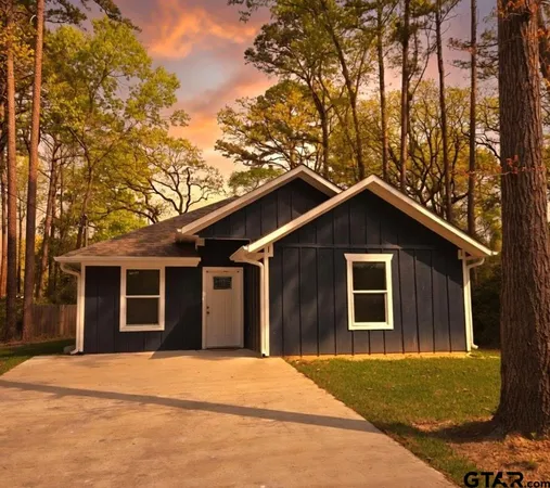 a front view of a house with yard and trees
