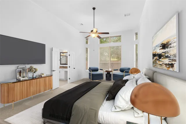 a bedroom with bed a mirror and a flat screen tv