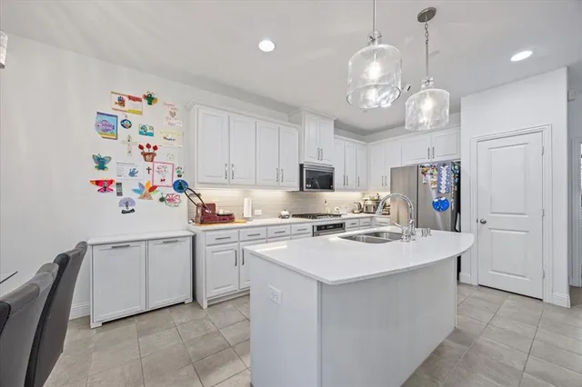 a kitchen that has a lot of cabinets and stainless steel appliances