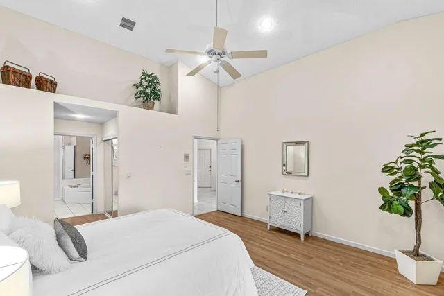 a bedroom with a bed dresser and a potted plant