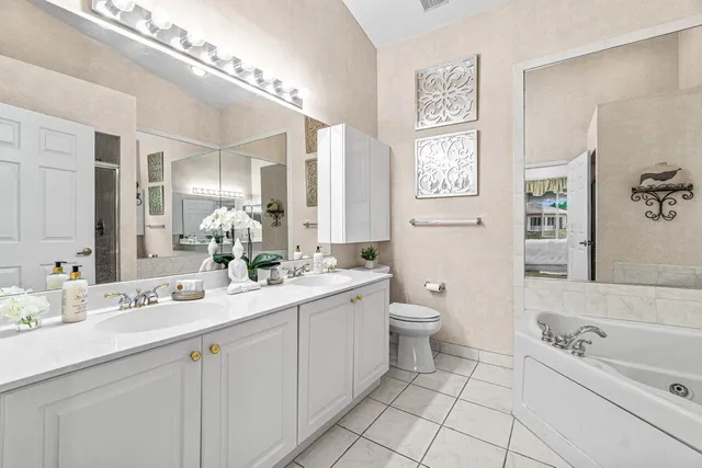 a bathroom with a double vanity sink a toilet and a mirror