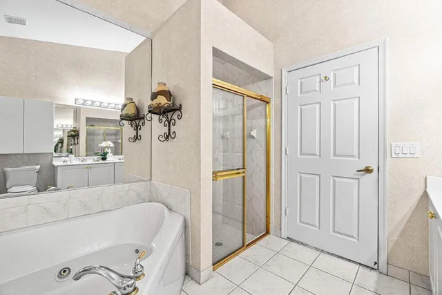 a bathroom with a tub shower and mirror