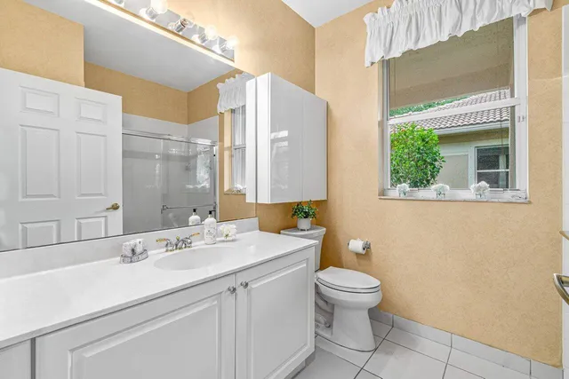 a bathroom with a double vanity sink toilet and a mirror