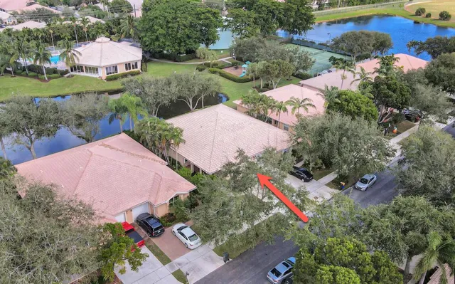 an aerial view of a house with a yard and lake