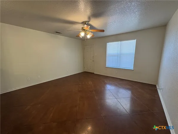 a kitchen with stainless steel appliances granite countertop a stove a sink a refrigerator white cabinets and wooden floor