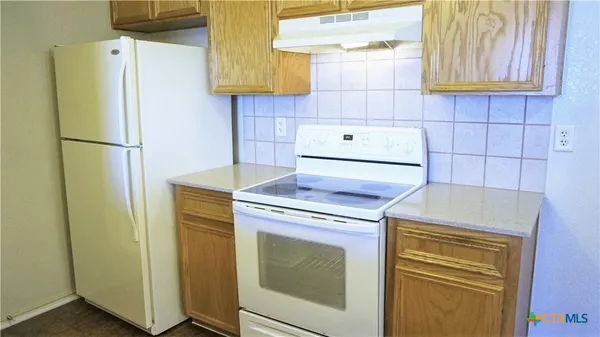 a kitchen with a refrigerator and a stove