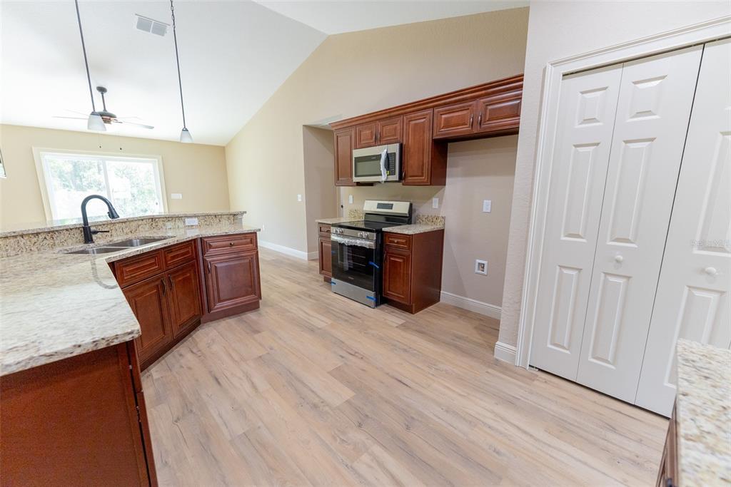 632 Southwest Fig Tree Lane Dunnellon, FL 34431 - Photo 19 of 58 a large kitchen with stainless steel appliances granite countertop a granite counter tops and a wooden floors