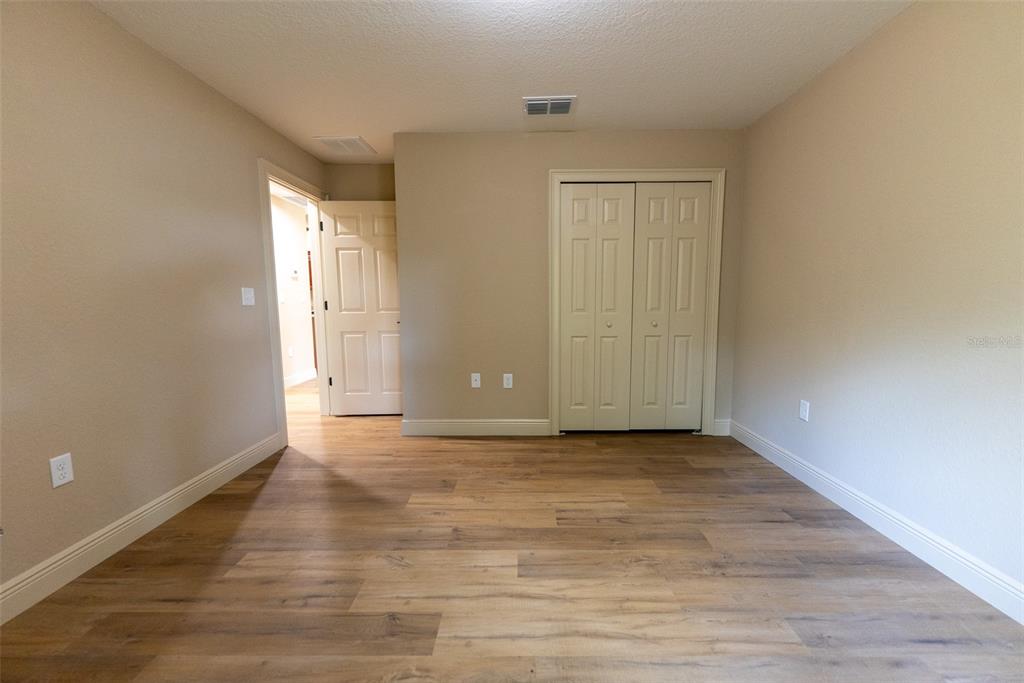 632 Southwest Fig Tree Lane Dunnellon, FL 34431 - Photo 54 of 58 a view of an empty room with wooden floor and a window