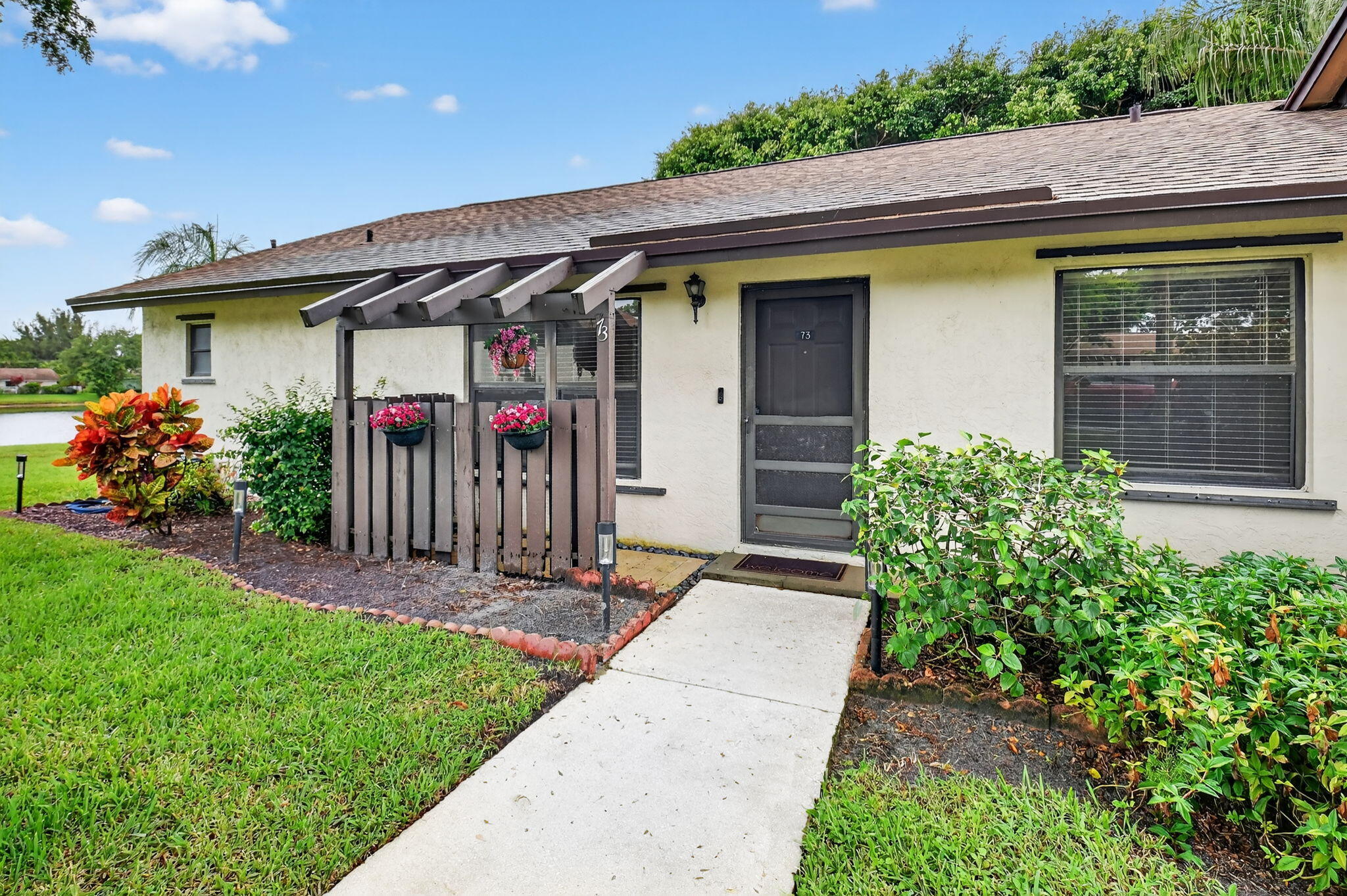 73 Vía De Casas Norte Boynton Beach, FL 33426 - Photo 2 of 60 a front view of a house with a porch