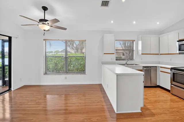 a kitchen with a sink appliances cabinets and a window
