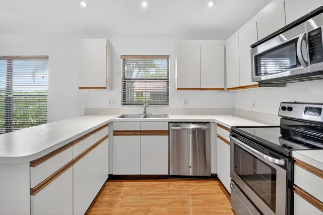 a kitchen with stainless steel appliances granite countertop a sink stove and microwave