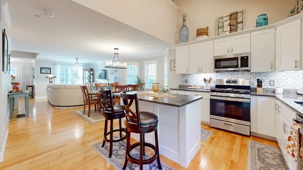 a kitchen with a table chairs microwave and cabinets