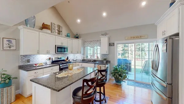 a kitchen with stainless steel appliances granite countertop a sink a stove and refrigerator