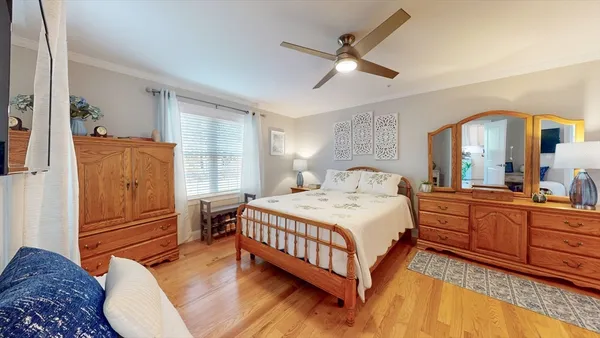 a bedroom with a bed and wooden floor