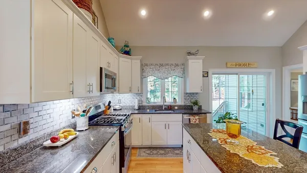 a kitchen with stainless steel appliances granite countertop a sink stove and wooden cabinets