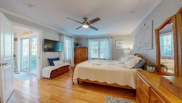 a bedroom with a bed wooden floor and window