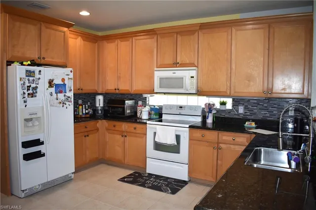 a kitchen with stainless steel appliances granite countertop a refrigerator sink and cabinets