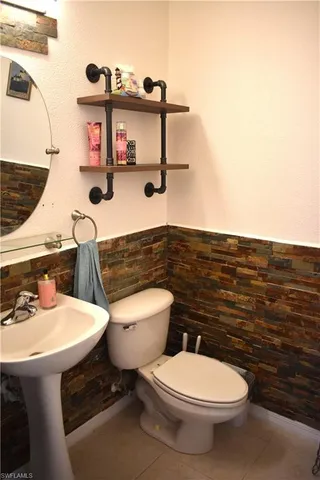 a bathroom with a sink a toilet and mirror