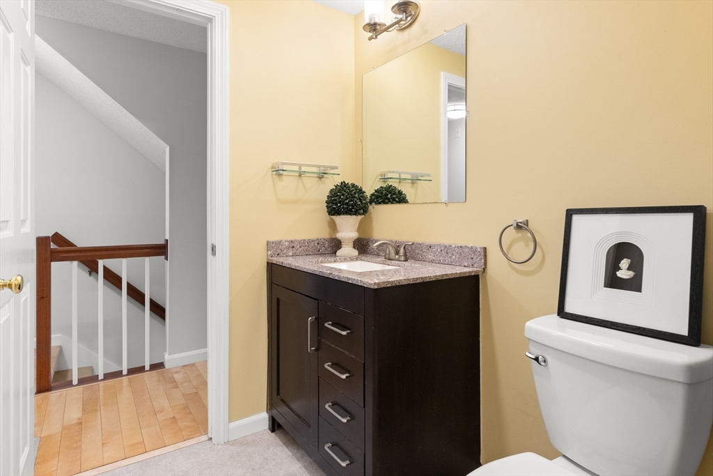 4203 Woodbridge Road, Unit 4203 Peabody, MA 01960 - Photo 18 of 31 a bathroom with a toilet a sink and a mirror