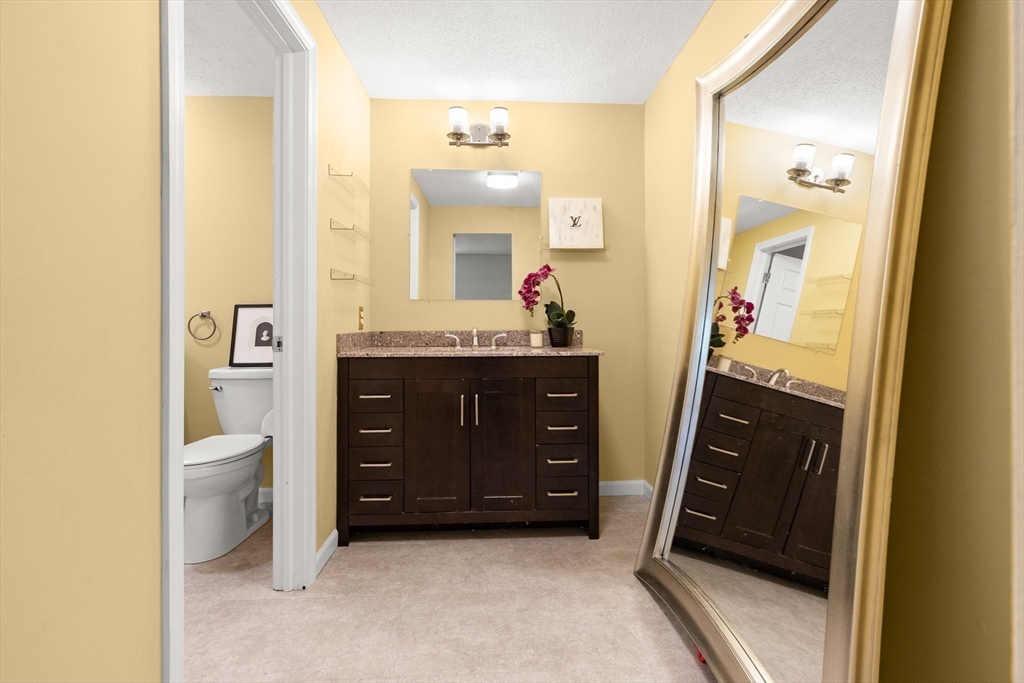 4203 Woodbridge Road, Unit 4203 Peabody, MA 01960 - Photo 19 of 31 a bathroom with a sink a vanity and a mirror