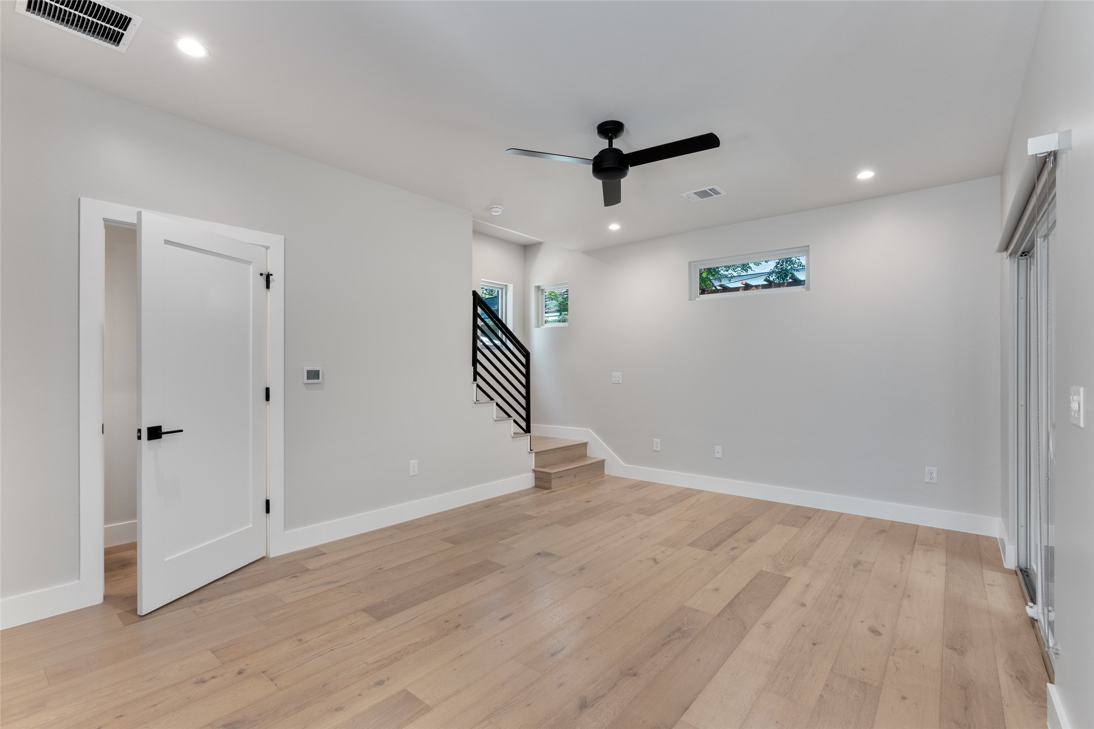 5200 Grover Avenue Austin, TX 78756 - Photo 10 of 32 Living area spacious and bright. Featuring light hardwood flooring, recessed lighting, and a contemporary ceiling fan.