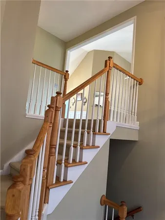 a view of staircase with lots of frames on wall and a window