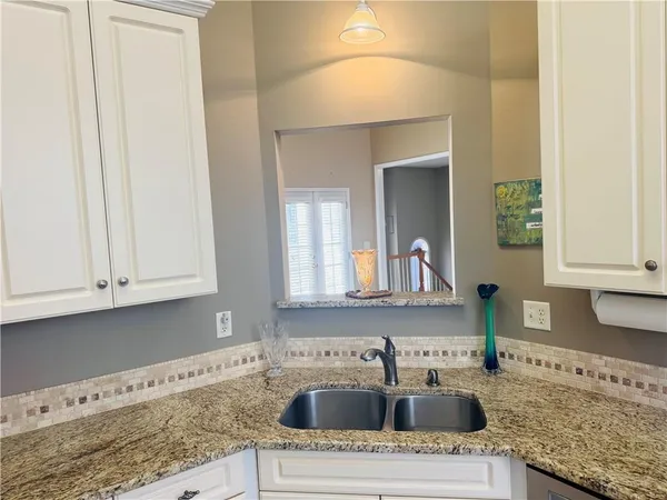 a kitchen with granite countertop a sink and a stove with wooden floor