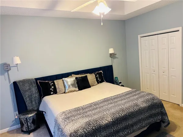 a bedroom with a bed a lamp and wooden floor