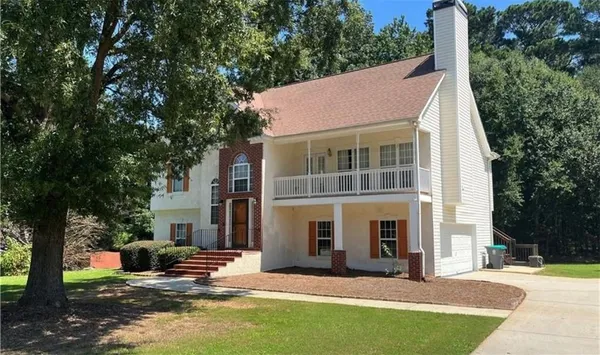 a view of a house with a yard and sitting area