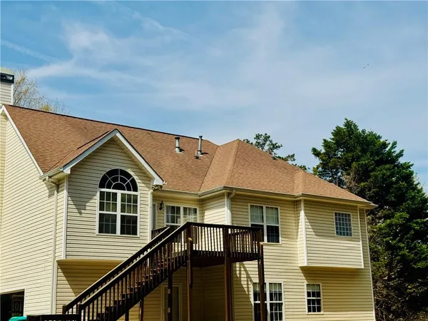 a view of a big house with wooden fence