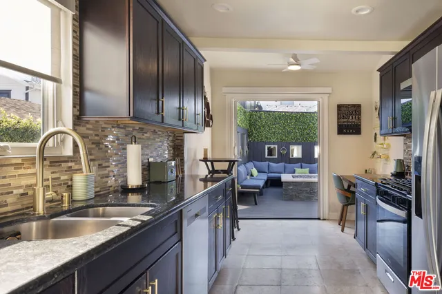 a kitchen with stainless steel appliances granite countertop a sink stove and cabinets