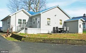 a view of a white house with swimming pool in front of it