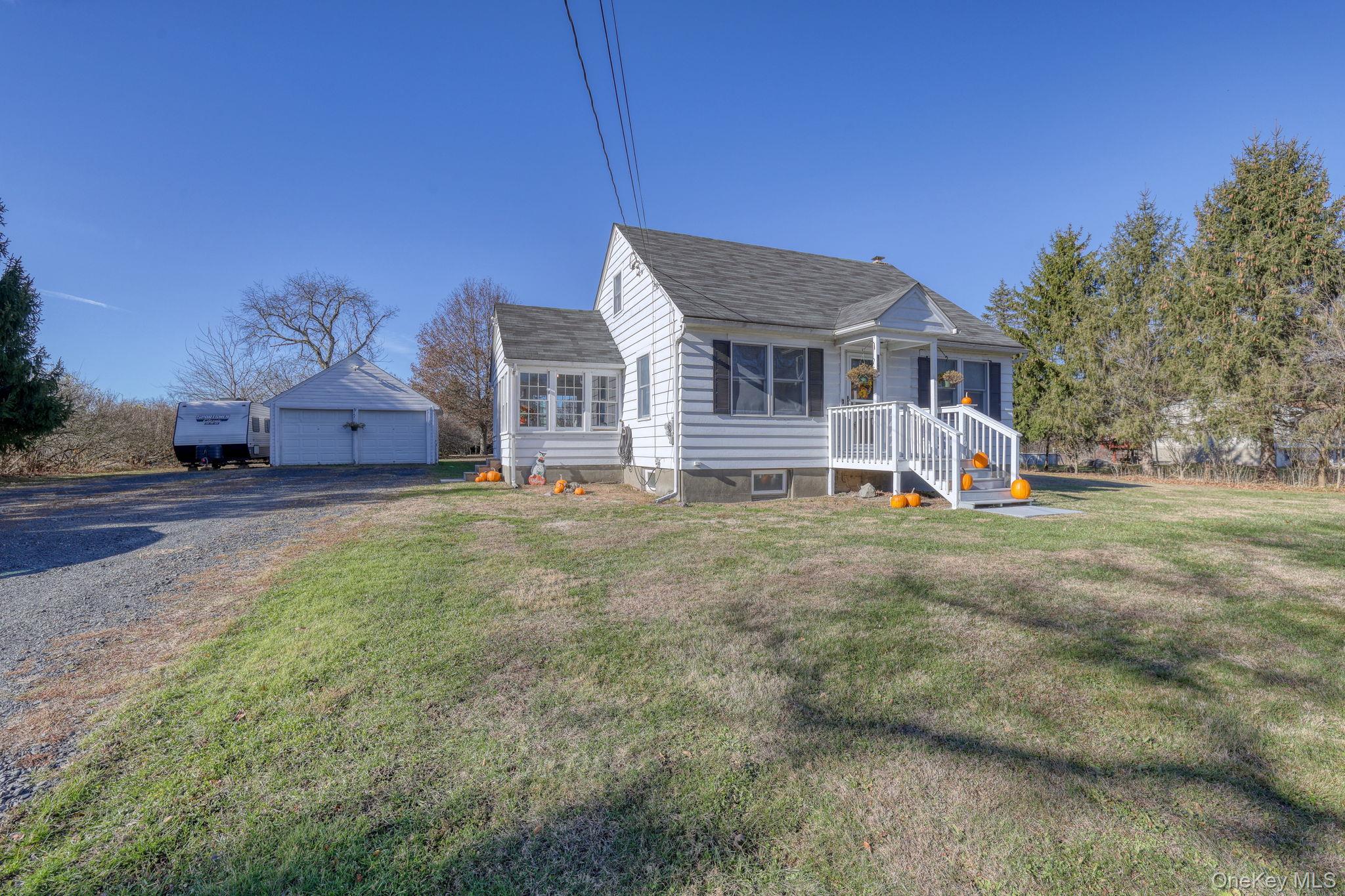 143 Plains Road Walden, NY 12586 - Photo 26 of 36 Bungalow-style home with an outbuilding, a detached garage, roof with shingles, and a front lawn