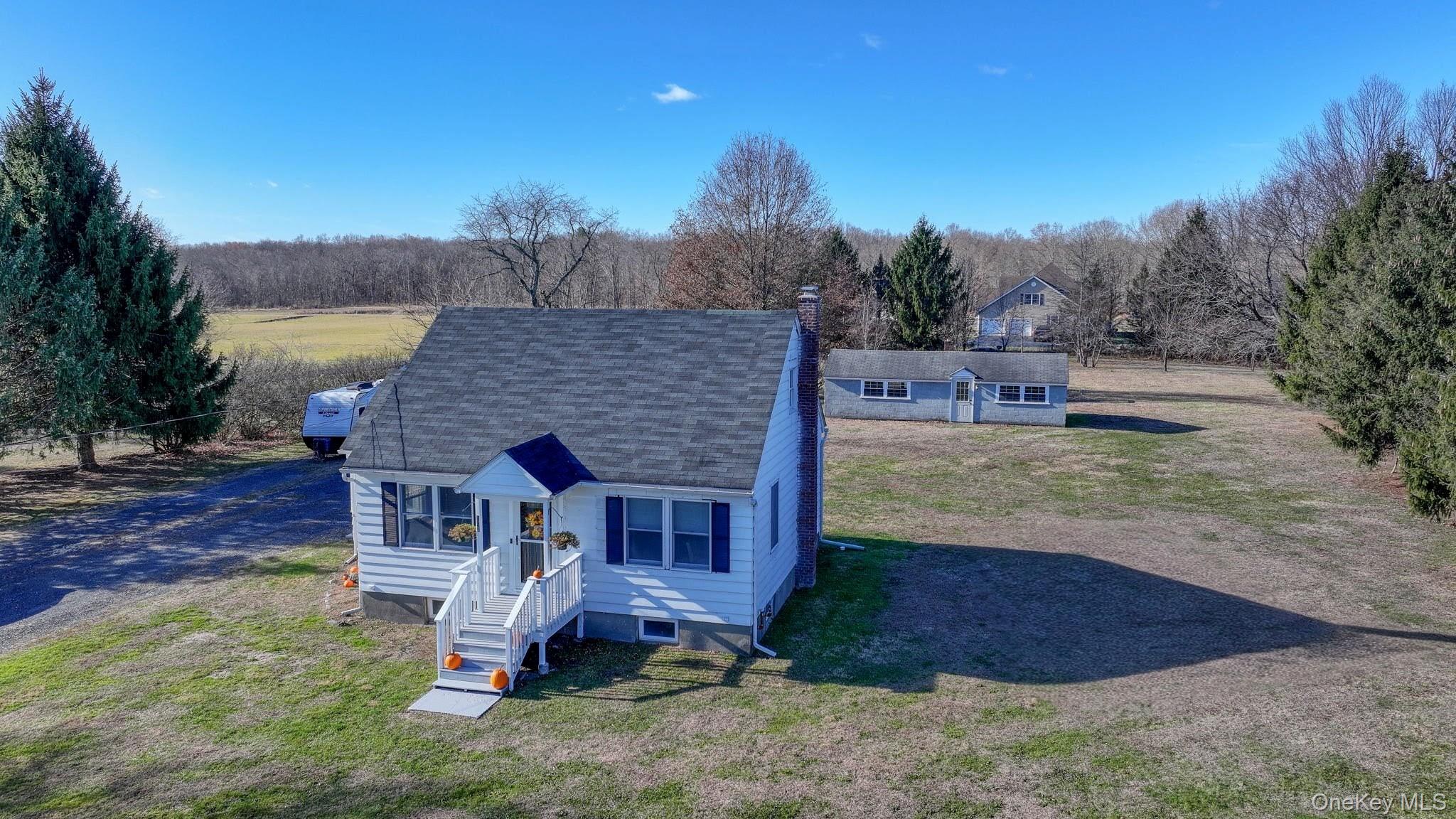 143 Plains Road Walden, NY 12586 - Photo 27 of 36 View of front facade with a shingled roof, a front lawn, and a chimney