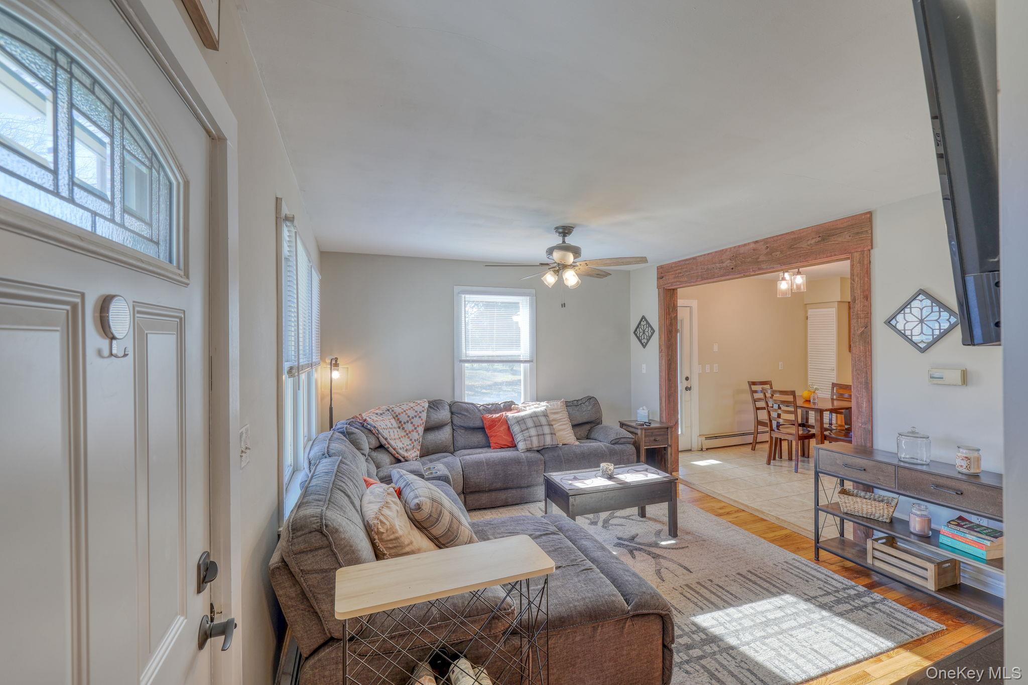 143 Plains Road Walden, NY 12586 - Photo 9 of 36 Living area with wood finished floors, baseboard heating, and a ceiling fan