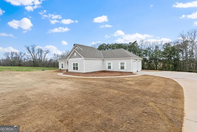a house with green field in front of it