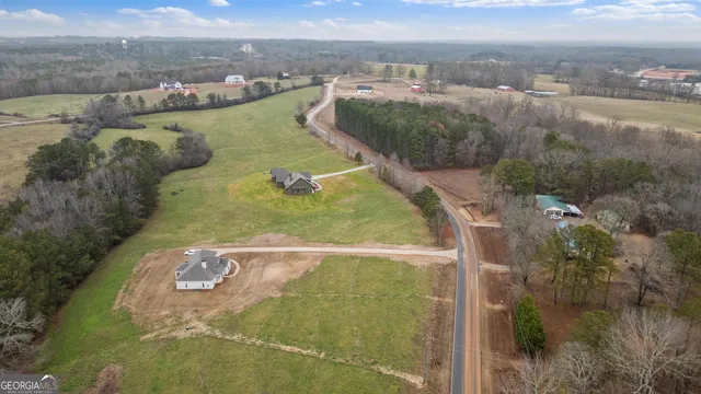 an aerial view of a house with swimming pool and a yard