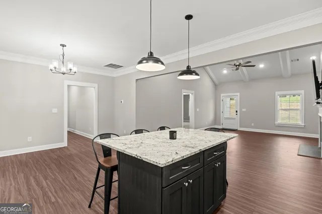 a kitchen with a table chairs and wooden floor