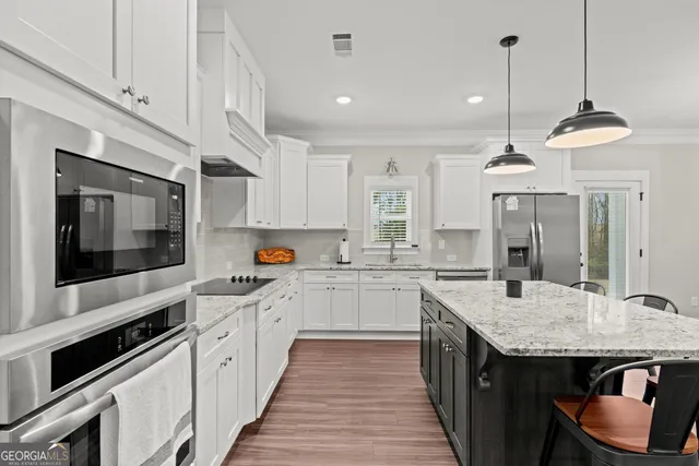 a kitchen with stainless steel appliances granite countertop a stove and cabinets